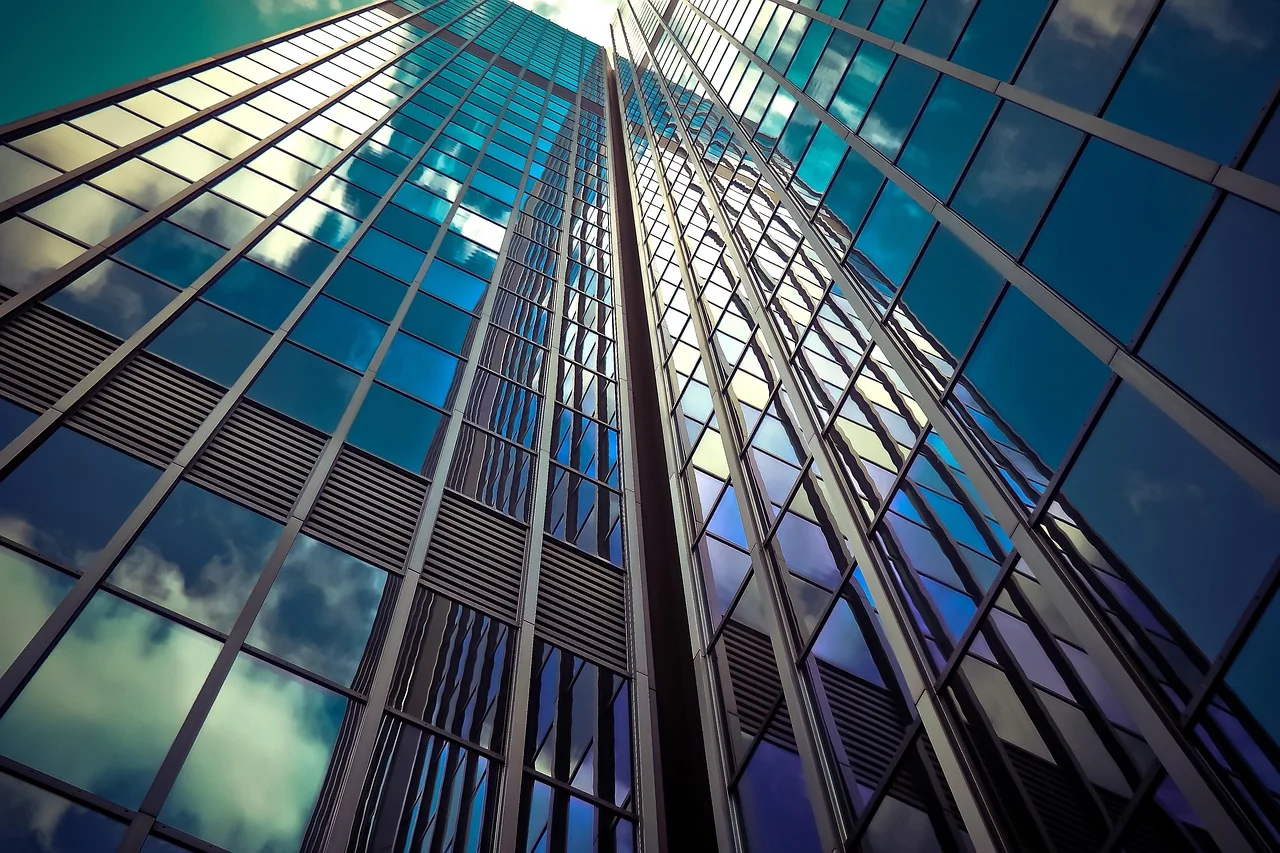 Glass office architecture rising toward an open sky