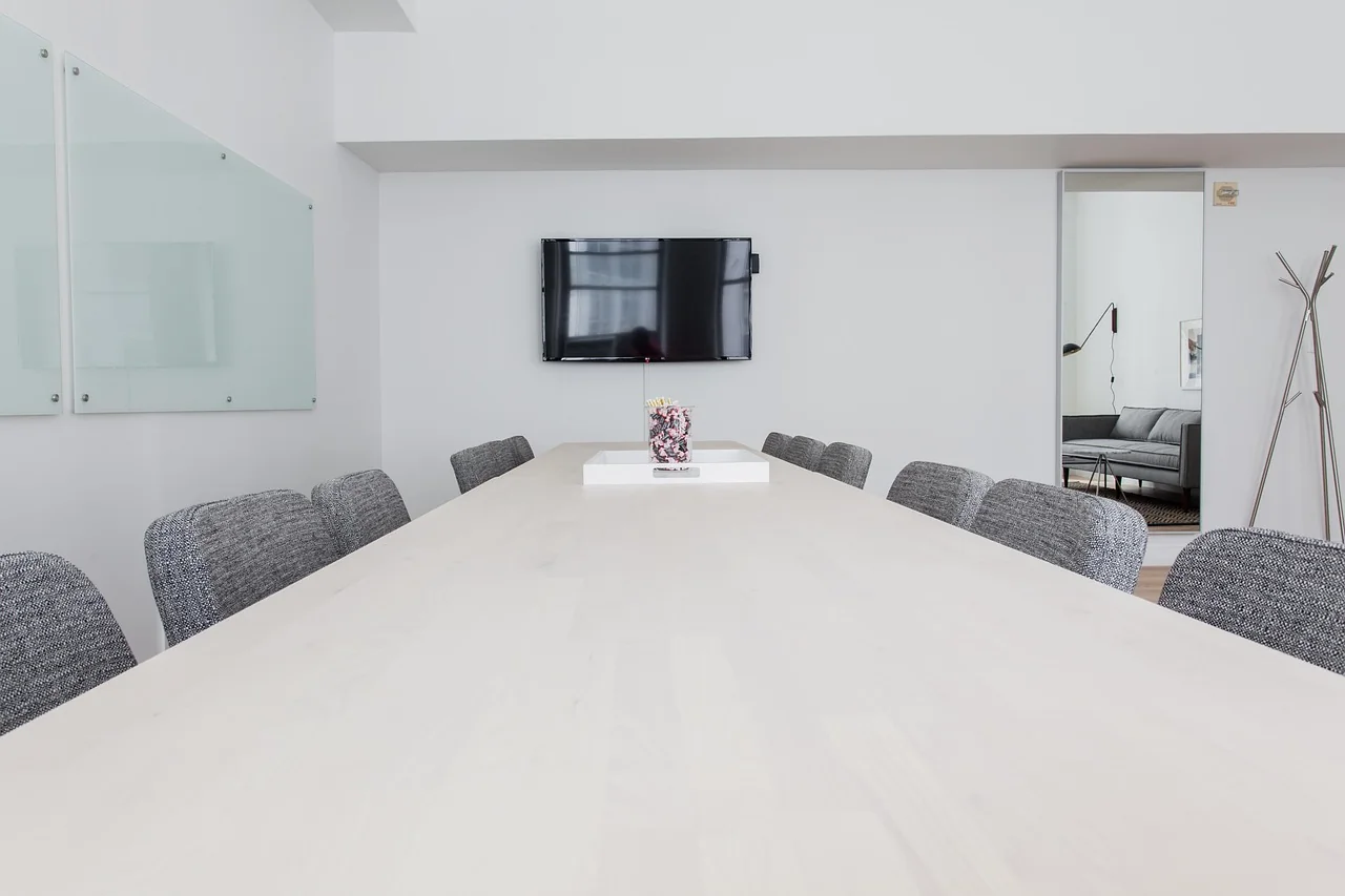 A bright conference room with a long table and chairs
